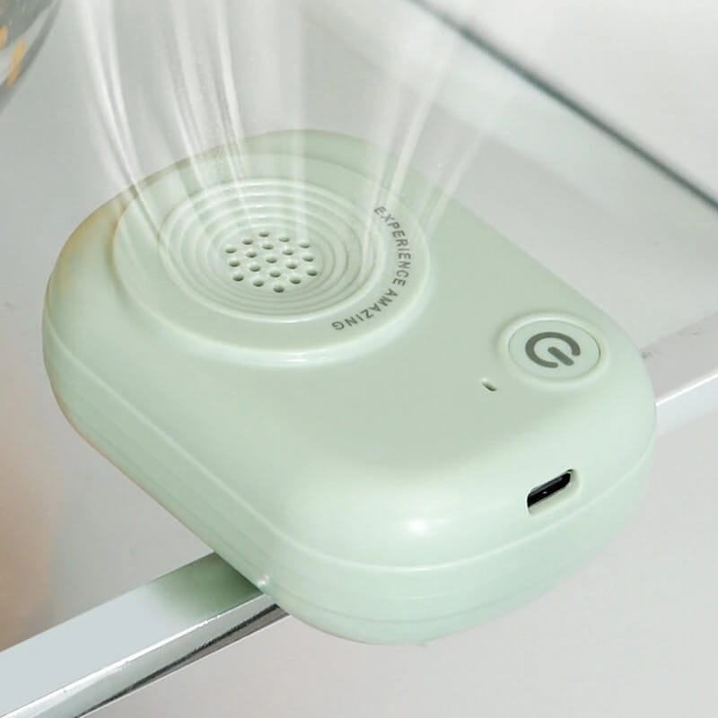 Dispositivo verde menta fissato al bordo di un ripiano del frigorifero, con la presa USB-C sul lato