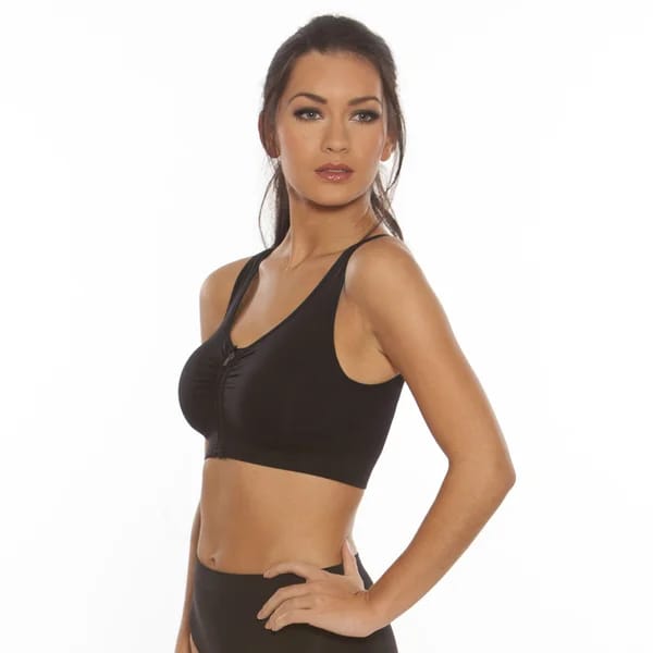 Modella di tre quarti con reggiseno sportivo nero senza ferretto e leggings, in posa su sfondo bianco